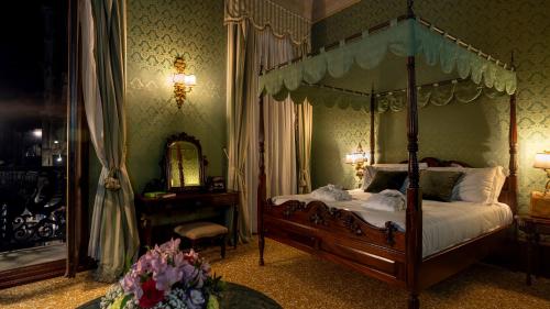 a bedroom with a canopy bed and a mirror at Hotel Al Ponte Dei Sospiri in Venice