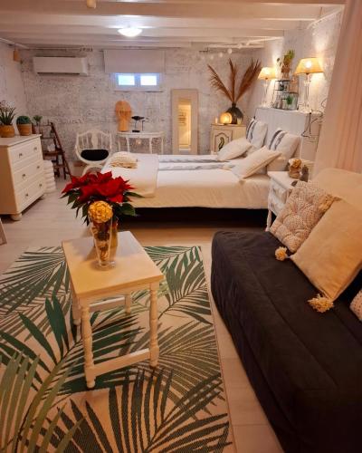 Cette grande chambre comprend 2 lits et une table fleurie. dans l'établissement Le Petit Nicol, à Bergerac