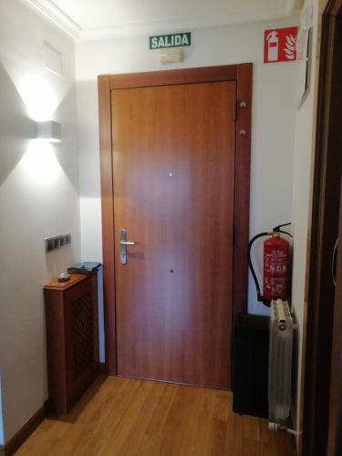 a wooden door in a room with a sign on the wall at El apartamento de Noe in Berrón