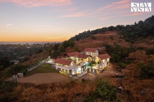 an aerial view of a house on a hill at StayVista at Ekan with Sea views, Pool, WiFi in Alibag