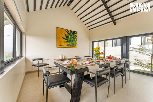 a dining room with a table and chairs at StayVista at Ekan with Sea views, Pool, WiFi in Alibag