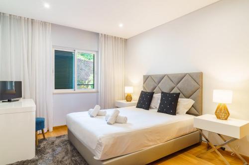 カニコにあるGuestReady - Ocean-View Retreat in Caniçoの大きな白いベッドとテレビのある寝室