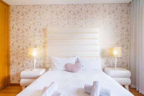 カニコにあるGuestReady - Ocean-View Retreat in Caniçoの大きな白いベッドと2つのランプのある寝室