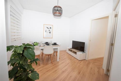 a white living room with a table and a tv at Lujoso Apartamento en Valencia 3 Dormitorios con Parking in Paterna