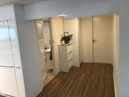 a small bathroom with white walls and wooden floors at Leilighet i sentrum i Frederikshavn - Grete in Frederikshavn