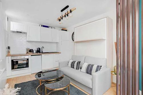 un salon blanc avec un canapé et une table dans l'établissement Cosy Apt - 2P - République - Marais, à Paris