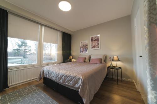 a bedroom with a bed with pink pillows and a window at Apartment Tullikatu in Kristinestad