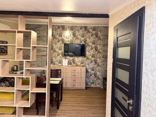 a dining room with a table and a tv on a wall at Апарт-отель "ГАЛАГОВЪ" in Uzhhorod