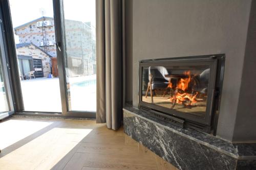 a fireplace in a living room with a fire at Ağva Casa Rosa Bungalov Otel in Sile