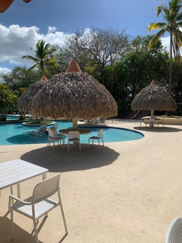 a group of chairs and umbrellas next to a pool at Private Resort Suite, Hotel Amenities & Golf in Las Lajas