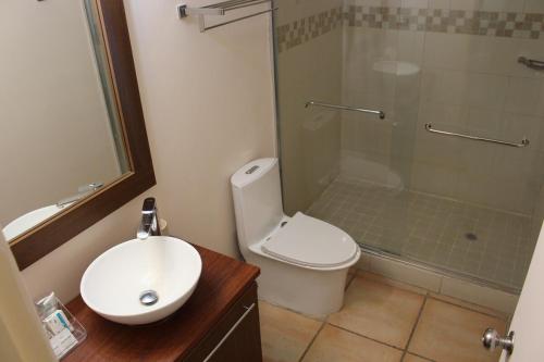 a bathroom with a toilet and a shower and a sink at Private Resort Suite, Hotel Amenities & Golf in Las Lajas