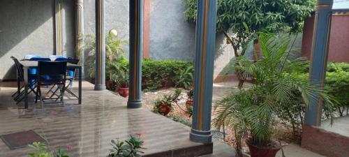 a patio with a table and chairs and plants at Villa Arsdou in Ségbé