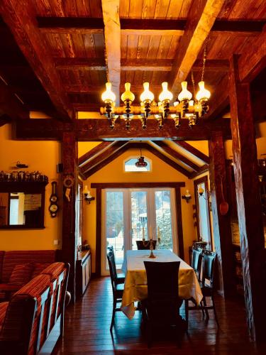 a dining room with a table and chairs and a chandelier at Chalet d'Argent in Dobreni