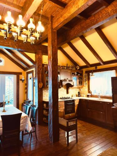 a kitchen with wooden ceilings and a table and chairs at Chalet d'Argent in Dobreni