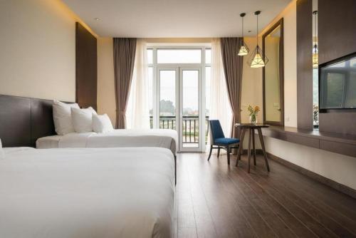 a hotel room with two beds and a window at Tuần Châu Resort Hà Nội in Phùng Thôn