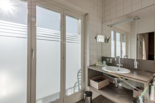 a bathroom with a glass shower and a sink at Boutique Hotel KARL in Luzern