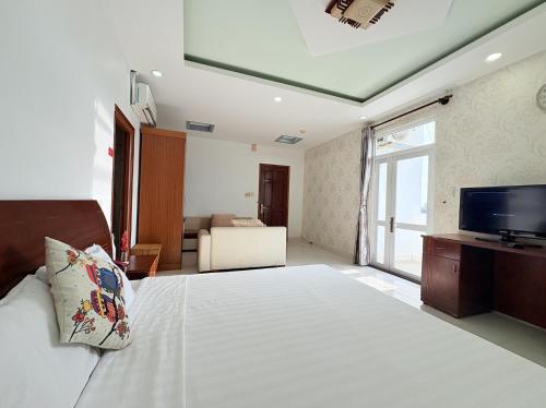 a bedroom with a large bed and a television at Palace Hotel - Rạch Giá in Rach Gia