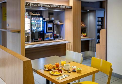 - une table avec de la nourriture dans un restaurant dans l'établissement B&B HOTEL Bordeaux Lormont, à Lormont