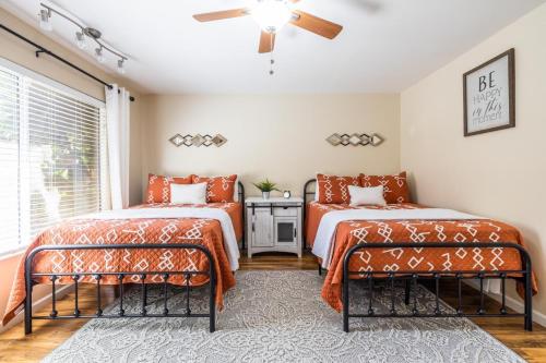 two beds with orange covers in a room with a window at Scottsdale Orange Blossom in Scottsdale