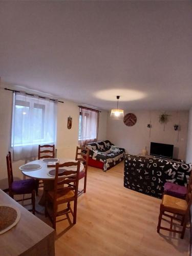 un salon avec une table et un canapé dans l'établissement Apparemment à la campagne, à La Bourgonce