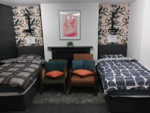 a bedroom with two beds and a table and chairs at Brighton Central Accommodation in Brighton & Hove