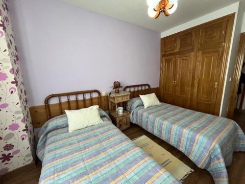 a bedroom with two beds and a ceiling at Rosancha in Lagunilla