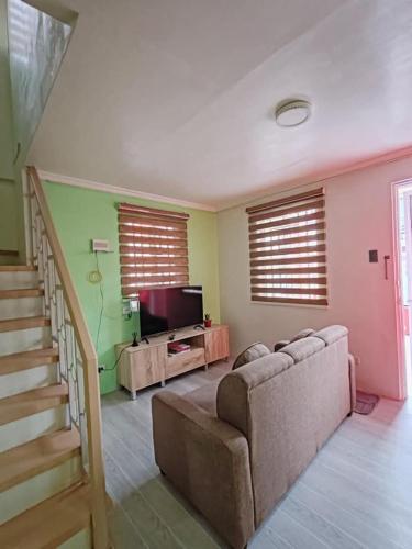 a living room with a couch and a television at Camella in Apalit