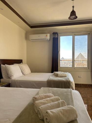 una camera d'albergo con due letti e una finestra di Isis Guest House a Il Cairo