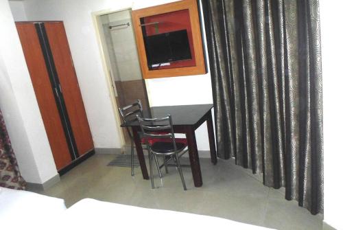 a room with a table and two chairs and a television at King Residency in Bengaluru