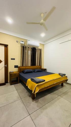 a bedroom with a large bed with a yellow blanket at Coastal Bliss Appartments in Varkala