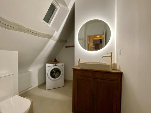 La salle de bains est pourvue d'un lave-linge et d'un miroir. dans l'établissement Charmante maison à pans de bois, Vernon centre, à Vernon