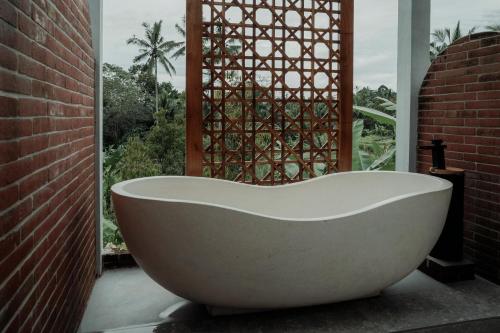 a bath tub sitting in front of a window at Wiwaka Harmony in Nature in Selat