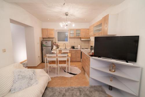a kitchen with a flat screen tv and a table at Mary's Downtown Home - a stroll away from Mount Vermio in Naousa Imathias