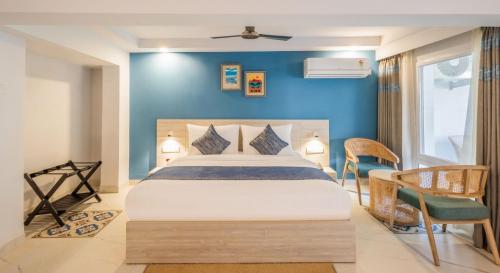 a bedroom with a bed and a blue wall at Goan Bliss in Varca