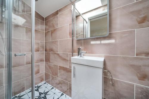 a bathroom with a shower and a sink and a mirror at Cottage in the heart of award-winning English village in Woodchurch