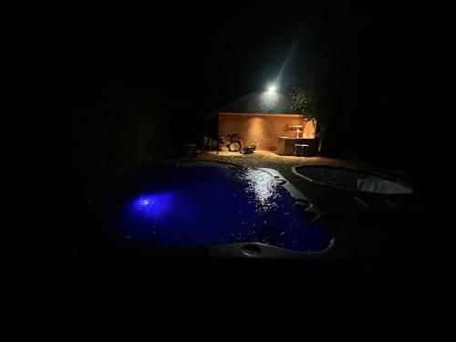 a blue bath tub in the dark with a light at 5 bed house with hot tub in Powick