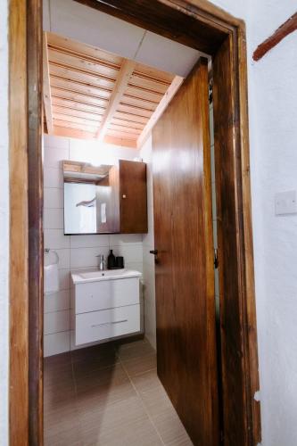 a bathroom with a sink and a wooden door at Rustic Elegance in Omodos in Omodos