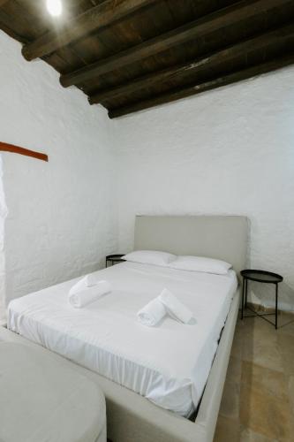 a white bed in a room with a wooden ceiling at Rustic Elegance in Omodos in Omodos