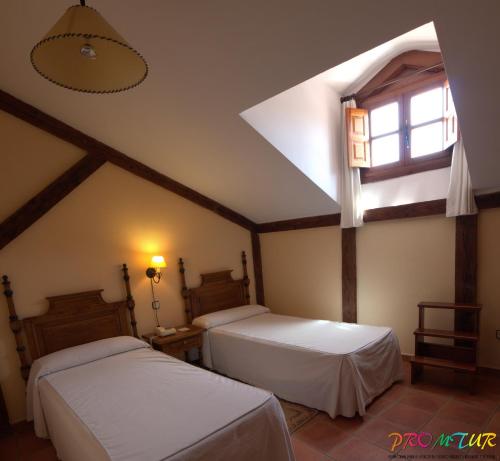 a bedroom with two beds and a window at Hotel Las Cancelas in Avila