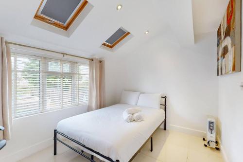 ein Schlafzimmer mit einem weißen Bett mit einem Fenster in der Unterkunft 1 Bedroom, Near Alexandra Palace - London - Kings Cross - New Southgate Suite 1 in New Southgate