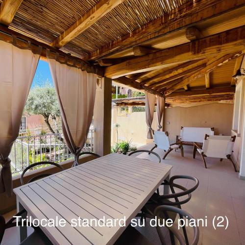 a patio with a table and chairs on a porch at Appartamenti Shardana in Villasimius