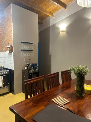 a dining room with a wooden table and a kitchen at Casa en el Quebrachito in Formosa