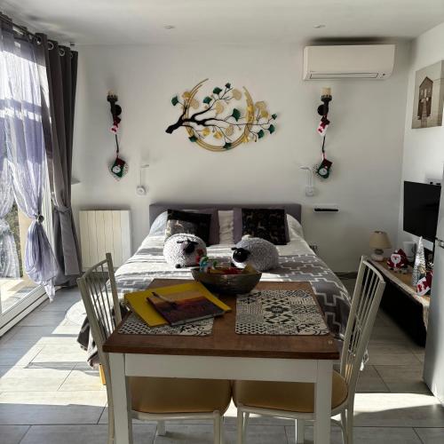 une salle à manger avec une table et un lit dans l'établissement Studio indépendant au pied des dentelles de Montmirail, à Violès