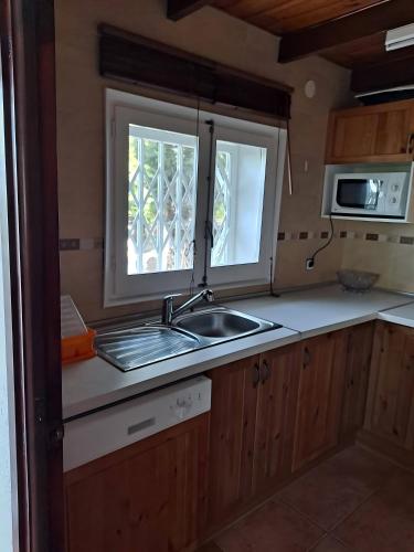 a kitchen with a sink and a window at Ca la calma in La Carroña