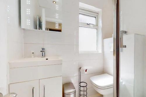 ein weißes Badezimmer mit Toilette und Waschbecken in der Unterkunft 1 Bedroom, Near Alexandra Palace - London - Kings Cross - New Southgate Suite 1 in New Southgate