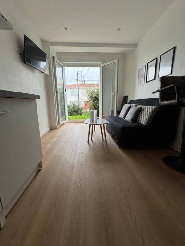 una sala de estar con un sofá y una mesa en Appartement 1 chambre vu sur jardin, en La Roche-sur-Yon