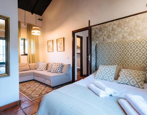 una camera da letto con un letto blu e un divano di Finca Rural Los Gorriones a El Garrobo