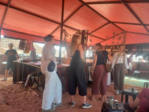 un grupo de personas de pie dentro de una tienda de campaña en wadi Rum Mohammed, en Wadi Rum