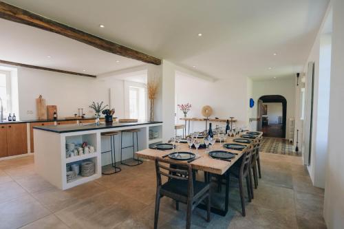 une salle à manger avec une grande table et une cuisine dans l'établissement Domaine des Tours, à Loix
