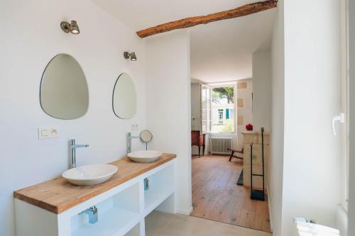 une salle de bain avec deux lavabos et deux miroirs dans l'établissement Domaine des Tours, à Loix